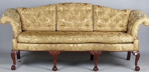 A George II style sofa with hump back, roll over arms and serpentine seat on four claw and ball feet, 220cm wide x 90cm high.