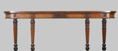 A William IV mahogany console, the shallow 'D' shape top on four foliate carved tapering reeded supports, 272cm wide x 93cm high.