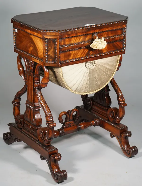 A William IV mahogany work table, the canted rectangular lift-top over single drawer and pull-out wool box, on opposing swan lyre supports, 54cm wide