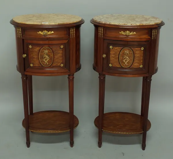 A pair of Louis XVI style bedside tables, each with marble inset oval top over a gilt metal mounted and kingwood base with single drawer over cupboard