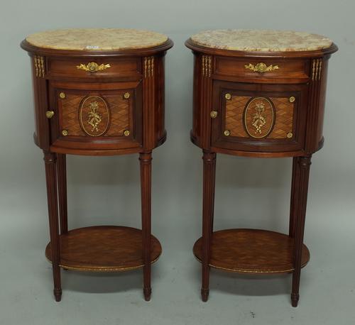 A pair of Louis XVI style bedside tables, each with marble inset oval top over a gilt metal mounted and kingwood base with single drawer over cupboard