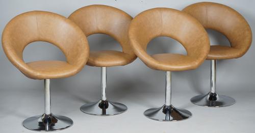 Retro design; a set of four tan leatherette upholstered swivel easy chairs with hoop backs and splayed polish metal supports, 69cm wide x 85cm high.