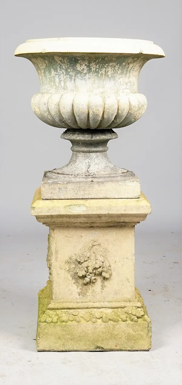 A 19th century stoneware garden urn with semi fluted body and turned socle on leaf moulded square base, 55cm diameter x 110cm high.