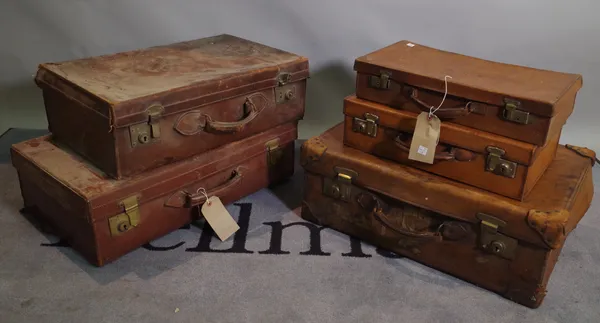 A group of five early 20th century leather bound suitcases, the largest 66cm wide x 18cm high, (5).