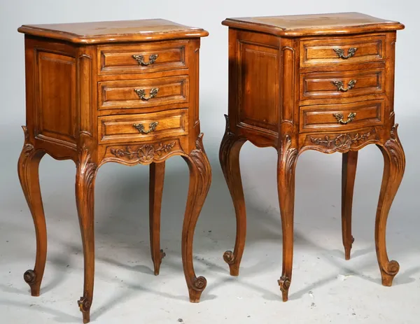 A pair of French walnut serpentine three drawer bedside tables of Louis XV style, on carved cabriole supports, 45cm wide x 76cm high.