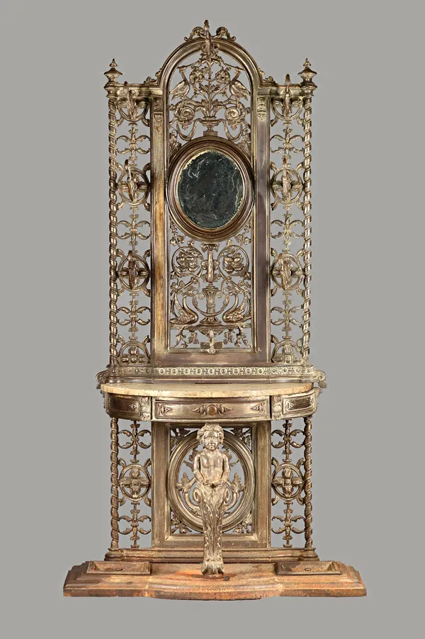 A cast iron coat and umbrella stand, the mirror back with pierced foliate decoration over marble demi-lune platform on cherub support, 89cm wide x 22c