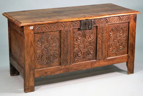 A 17th century oak coffer, with carved triple panel front, on block feet, 146cm wide x 75m high.