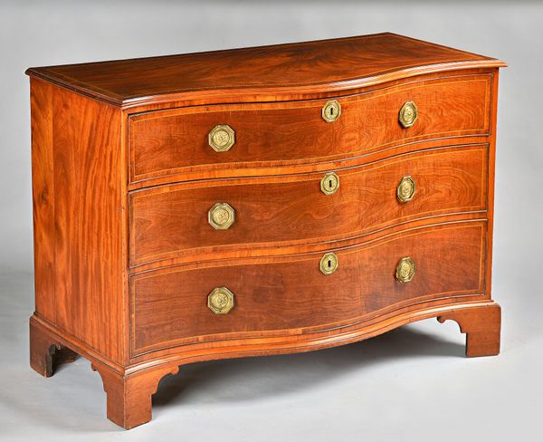 A George III featherbanded mahogany serpentine chest of three long graduated drawers on bracket feet, 123cm wide x 88cm high.Illustrated