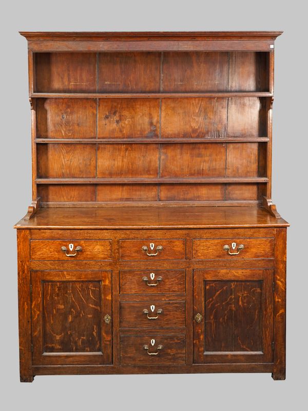 A mid-18th century oak dresser, the enclosed three tier plate rack over six short drawers and a pair of cupboards, 151cm wide x 190cm high.