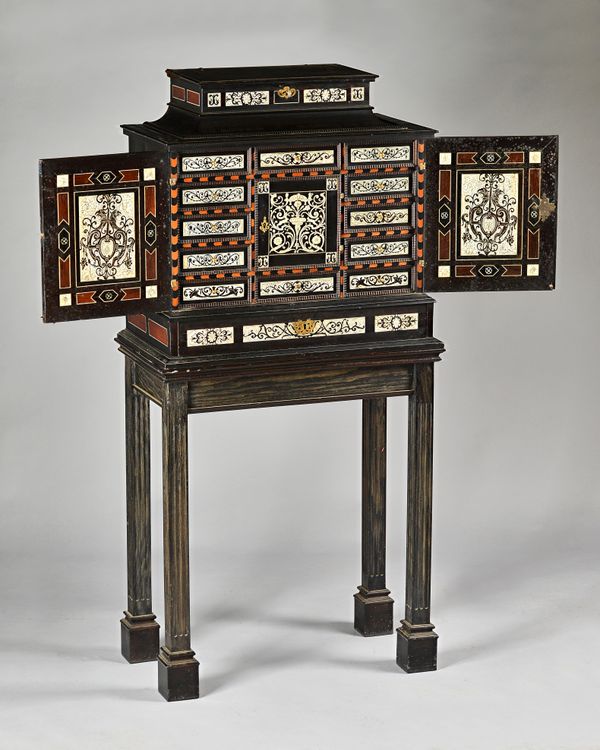 A mid-19th century Milanese ivory, rosewood and mahogany inlaid ebonised cabinet, the hinged swept top over a pair of doors enclosing eleven drawers c