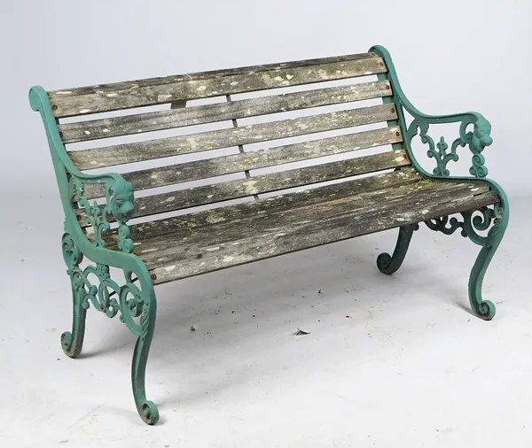 A 20th century green painted cast iron garden bench, with lion mask arm terminals and scroll supports united by wooden slats, 130cm wide x 78cm high.