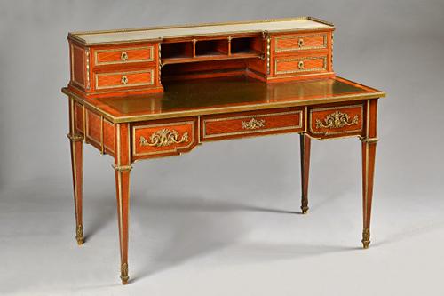In the manner of Jean Henri Riesener; a late 19th century ormolu mounted mahogany writing desk of Louis XVI style, the marble top superstructure with