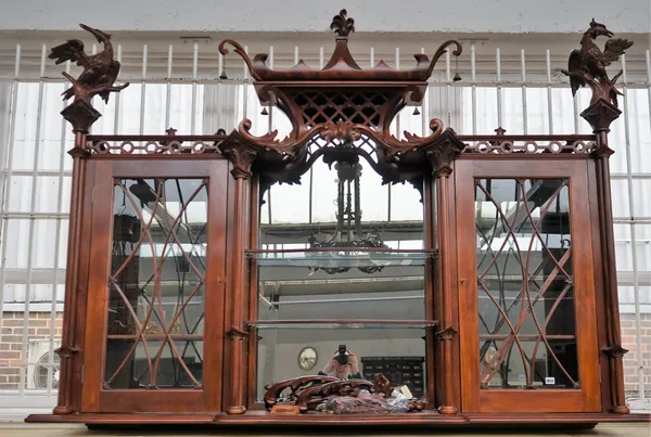 A pair of Chippendale revival mahogany hanging display shelves with pagoda tops and ho ho bird finials, over a pair of glazed doors and open shelves,