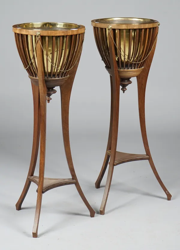 A pair of Edwardian mahogany jardinieres with open slatted brass lined bodies on three splayed supports, 35cm diameter x 96cm high.