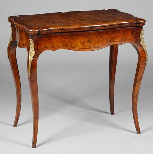 A Victorian gilt-metal mounted figured walnut card table with serpentine fold over top on cabriole supports, 81cm wide x 78cm high.
