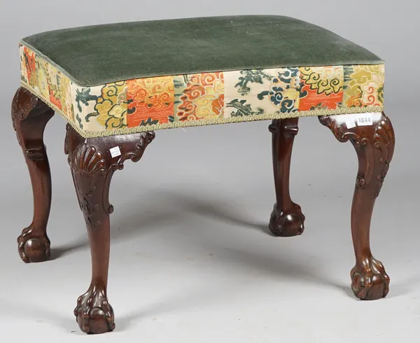 A George II style mahogany framed rectangular footstool on shell capped claw and ball supports, 66cm wide x 50cm high.