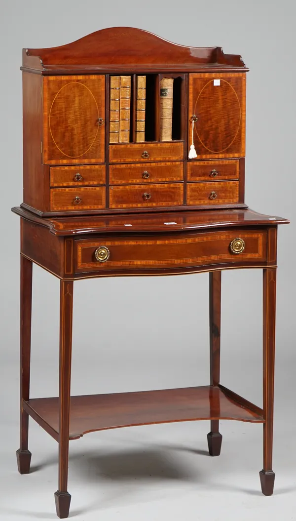 An Edwardian satinwood banded mahogany side cabinet, the superstructure with seven drawers, pigeon holes and cupboard, the associated base with serpen