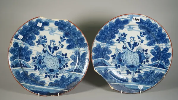 A pair of Dutch Delft blue and white dishes, 18th century, each painted with a figure of Flora seated holding a cornucopia of flowers between rocks an