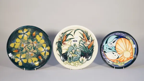 Three Moorcroft Pottery plates comprising; water lilies against a cream ground, 26cm diameter, stylised doves by Emma Bossons, 22cm diameter, and one