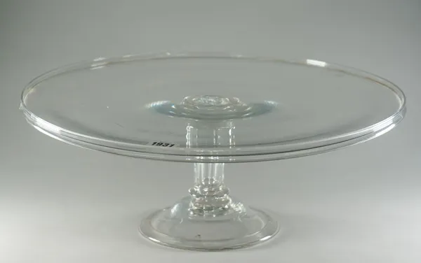 A large glass tazza, late 18th century, the circular tray with raised rim, raised on a wrythen moulded pedestal stem and domed foot, 46cm diameter.