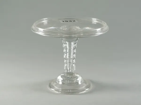 A glass patch stand, 18th century, the galleried round tray top supported on a bobbin stem and domed foot, 13cm diameter.