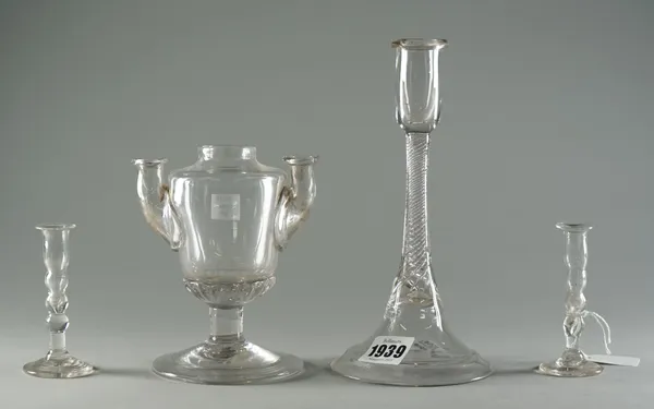 An airtwist glass candlestick, mid-18th century, the cylindrical nozzle set on a multi-series airtwist stem and flared base, 20cm.high; a pair of mini