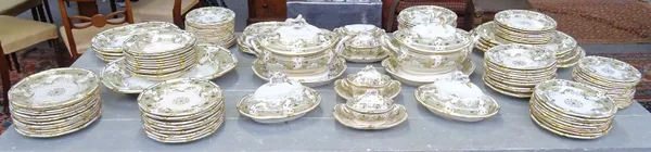 An extensive Davenport porcelain dinner service, circa 1840, painted with a central gilt foliate medallion inside an eau de nil and gilt foliate borde