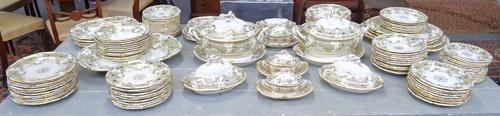 An extensive Davenport porcelain dinner service, circa 1840, painted with a central gilt foliate medallion inside an eau de nil and gilt foliate borde