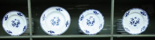 A Tournai porcelain composite blue and white table service, late 18th/19th century, each piece painted with flowering plants and an insect, the border