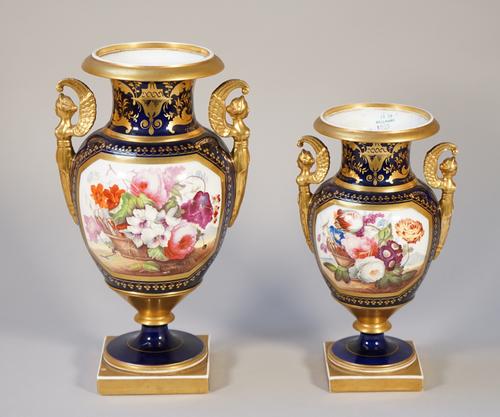 A garniture of three English porcelain two-handled vases, possibly Davenport, circa 1820-30, each set with gilt winged caryatid handles, painted with