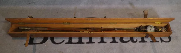 An early 20th century fishing rod box, 138cm long, containing split cane rods and reels.