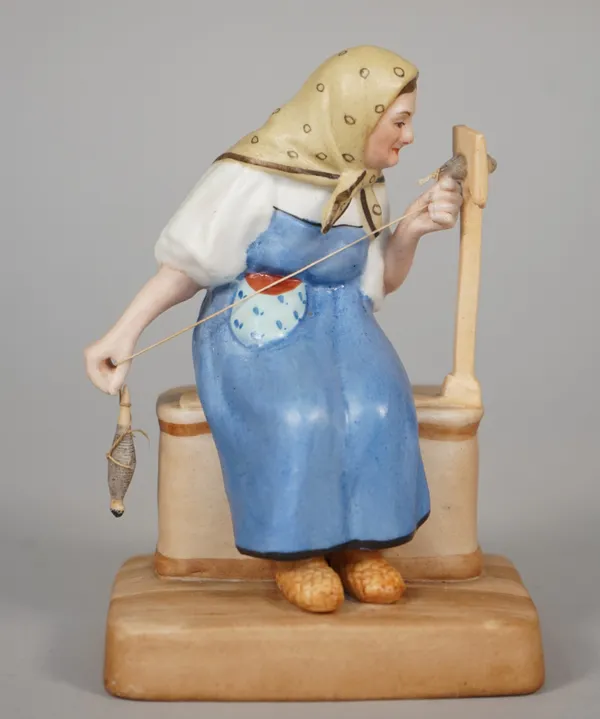 A Russian biscuit porcelain figure of an old woman carding wool, Gardner factory, late 19th century, red printed mark, 13cm high.