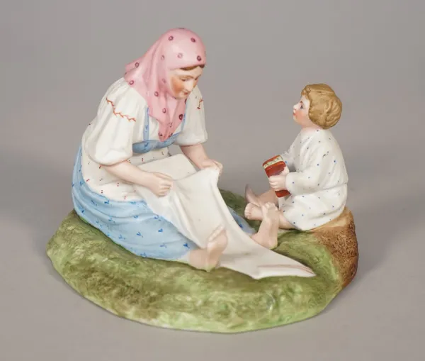 A Russian biscuit porcelain figure group of mother and child, Gardner factory, late 19th century, red printed mark, 9.5cm high.