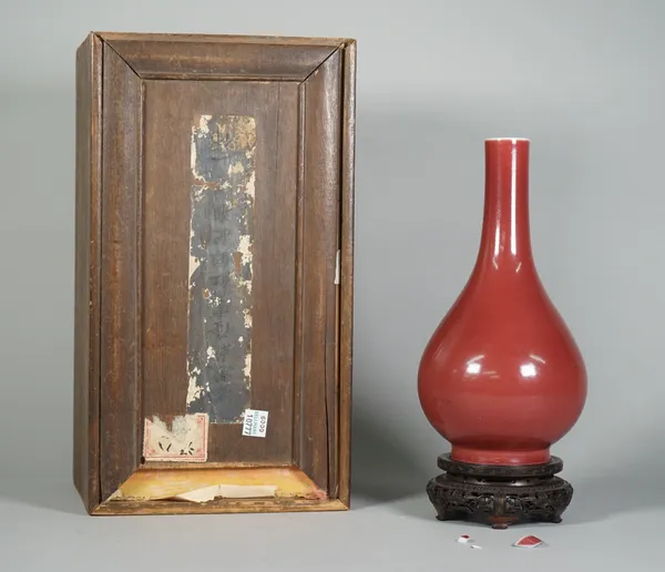 A Chinese flambé glazed vase, 18th/19th century, of pear form covered in a deep red glaze, (a.f), 22.5cm high, wood stand and fitted box.