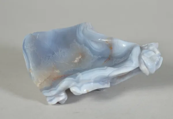 A Chinese agate brushwasher, 19th/20th century, in the form of a lotus leaf, the stone of lavender tone, (a.f), 10.25cm long.