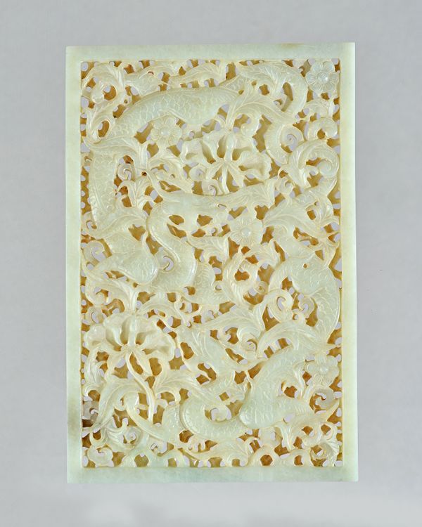 A Chinese celadon jade openwork plaque, possibly 17th century or later, of rectangular form, pierced and carved with two dragons amongst prunus, peony