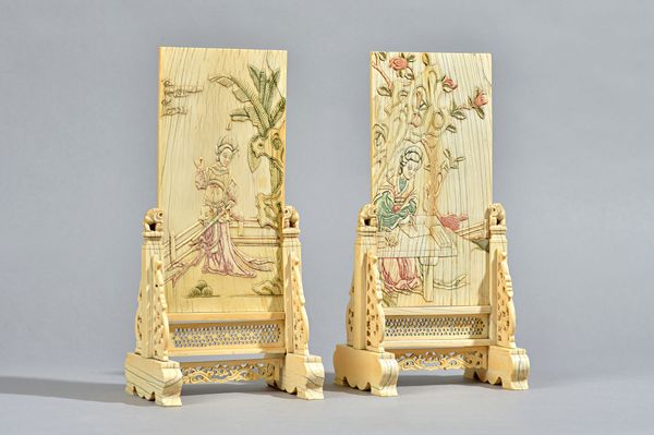 A pair of Chinese ivory table screens and stands, Qing dynasty, each rectangular panel carved and stained with a woman in a garden, the reverse with l