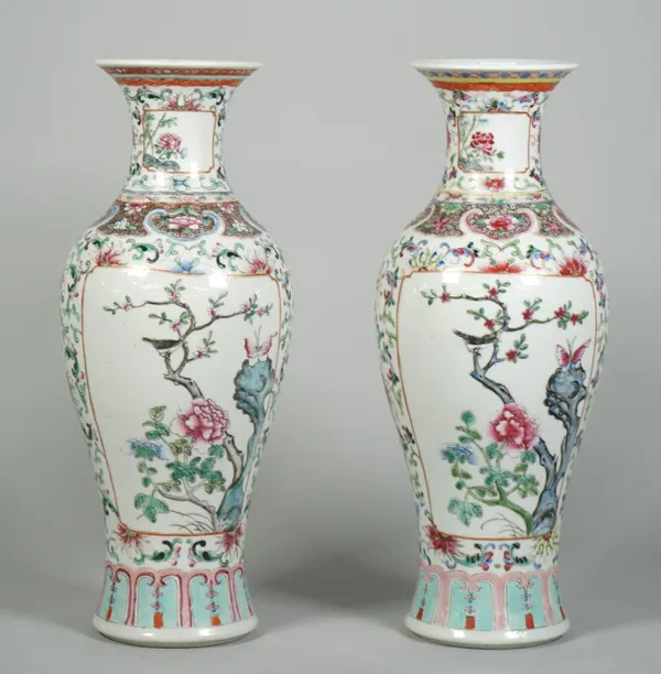 A pair of Chinese famille-rose slender baluster vases, circa 1900, each painted with two panels of birds in flowering branches against a white ground