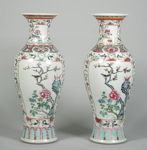 A pair of Chinese famille-rose slender baluster vases, circa 1900, each painted with two panels of birds in flowering branches against a white ground