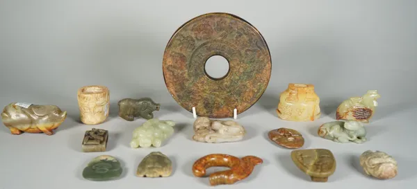 A group of Chinese archaistic jade carvings, of various colour and size, comprising; a large bi disc, 15cm. diameter; a sword slide, 4.5cm. wide; a be