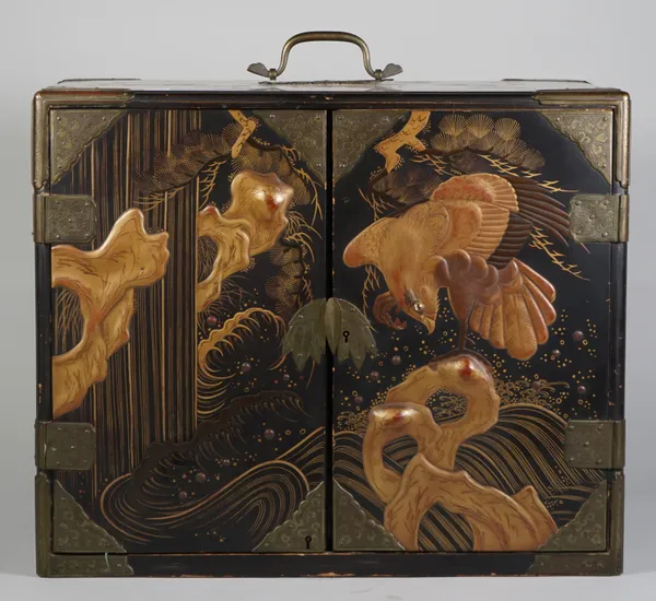 A Japanese black lacquer two door table cabinet, Meiji period, of rectangular form, decorated in raised gold lacquer with a ho-o bird flying amongst b