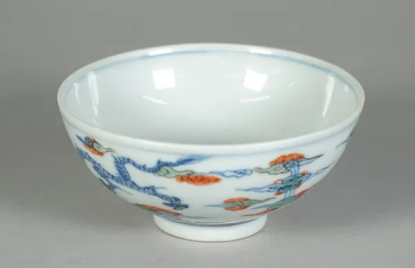 A small Chinese porcelain bowl. blue six character Yongzheng mark but later, painted in doucai style with two dragons amongst cloud scrolls, 9.5cm. di