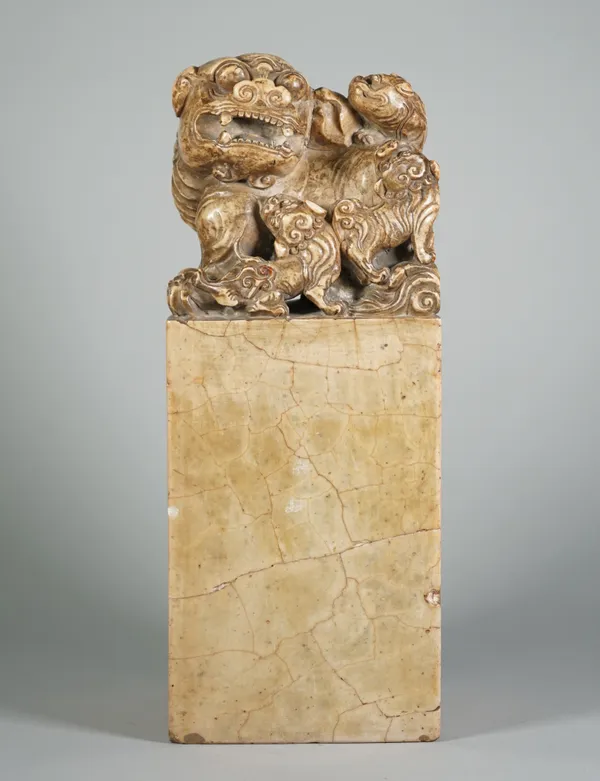 A large Chinese soapstone seal, late 19th/20th century, of square section, surmounted by a Buddhist lion and cubs, 33cm. high.