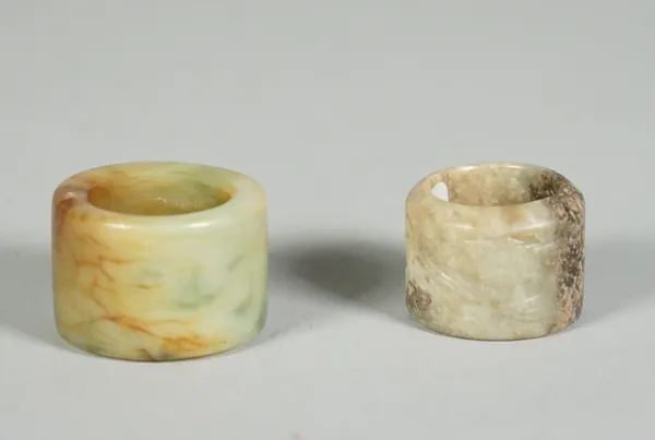 A Chinese jade archer's ring, Qing dynasty, carved with two deer, the stone of greyish green tone with black inclusion, 3cm. diameter; and a larger ja