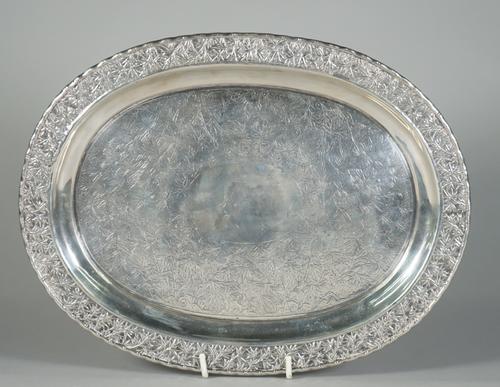 A Chinese export silver salver, mark of Hoaching, late 19th century, of oval form, the centre chased with bamboo and rocks around a central plain oval
