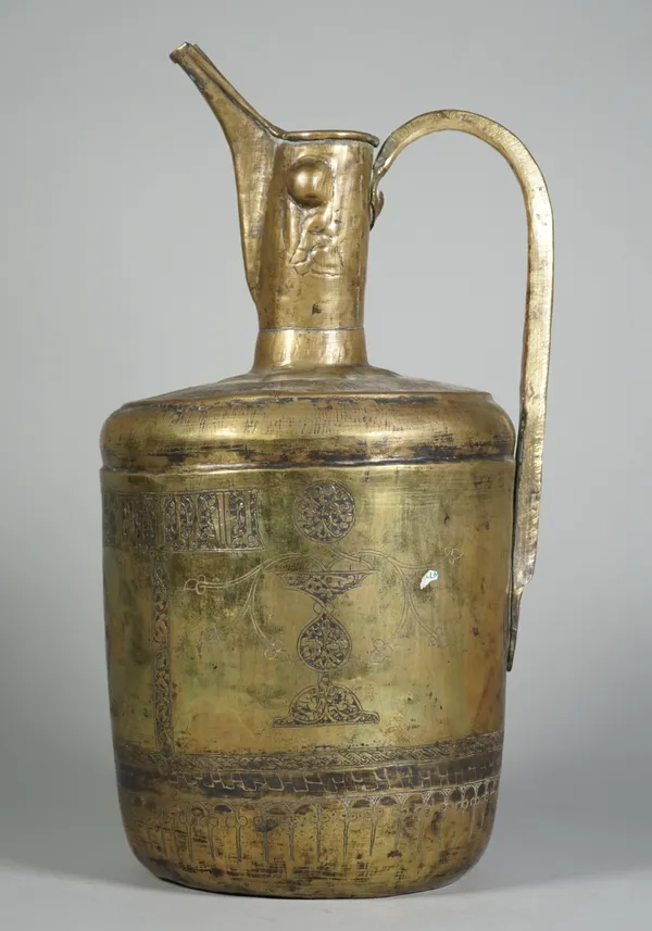 A Khorassan high spouted  brass ewer, probably 12th/13th century, of cylindrical form with cylindrical neck and loop handle, the body engraved with a
