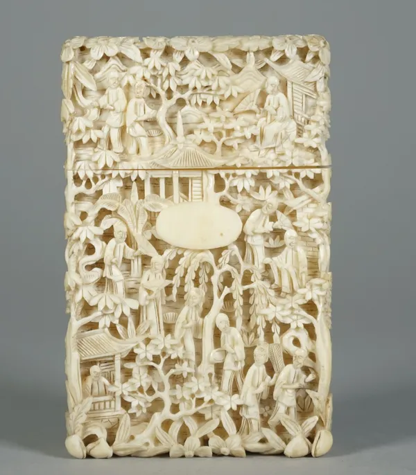 A Canton ivory rectangular card case, late 19th century, profusely carved with figures amongst trees and pavilions,one side with small oval cartouche,