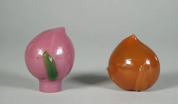 Two Peking glass snuff botlles, each in the form of a peach, one of purple glass with green leaves, the other of butterscotch tone, 5cm. and 4.5cm. hi