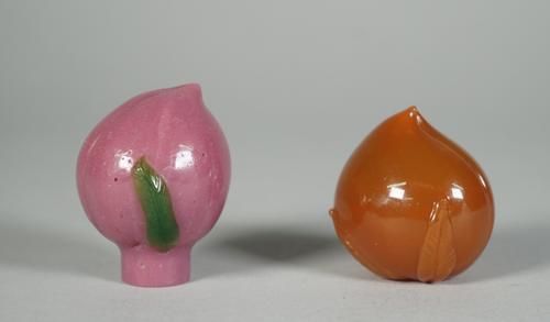 Two Peking glass snuff botlles, each in the form of a peach, one of purple glass with green leaves, the other of butterscotch tone, 5cm. and 4.5cm. hi