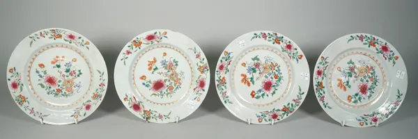 Four Chinese famille-rose plates, Qianlong, each painted in the centre with a vase and flowers, the border scattered with flower sprays, (a.f), 23cm.